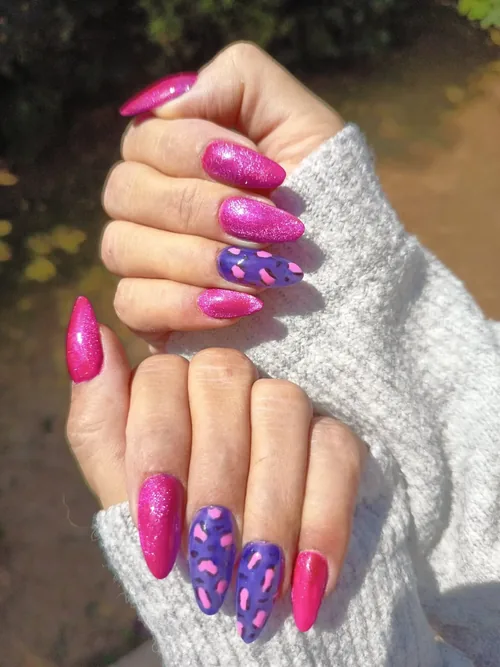 Ongles rose fuchsia pailleté avec nail art violet à motifs, ongles longs amande